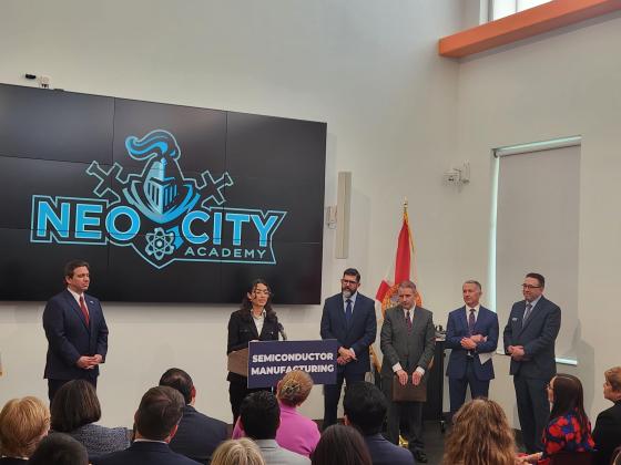 NeoCity Academy senior Yesenia Hernandez speaks about the state’s semiconductor manufacturing investments at an event at the school Friday attended by (from left) Gov. Ron DeSantis, Department of Education Commissioner Manny Diaz, Florida Secretary Alex Kelly, Osceola County Manager Don Fisher and Skywater Technologies Senior Vice President Brad Ferguson. PHOTO/KEN JACKSON