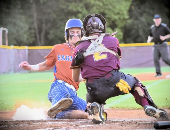 Harmony's Nate O'Neill slides into home as St. Cloud catch Josh Bejarano attempts to apply the tag in Friday's 11-1 Longhorn win in the OBC championship game. PHOTO/KATIE WILLIAMS