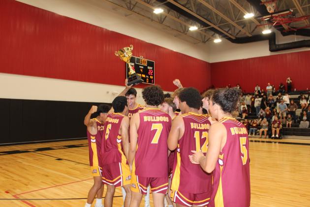 Championes! The Bulldogs celebrate with the OBC boys volleyball championship trophy. PHOTO/KEN JACKSON