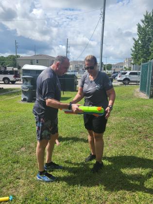St. Cloud Police Chief Doug Goerke and Community Engagement Officer Lin Badman-Paton inspect their arms for the water gun battle Friday ... PHOTO/KEN JACKSON