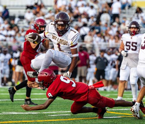 St. Cloud running back Michael Cuyler hurdles an Innovation defender in Friday's 45-0 Kickoff Classic win. PHOTO/TAYLOR MCFEE