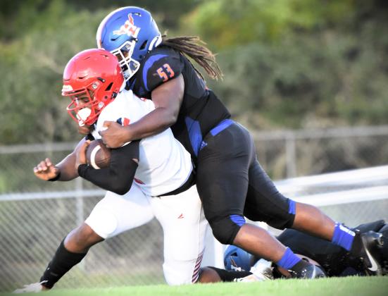Harmony defensive lineman Mekhi Ealy drags down Poinciana quarterback Cameron Brown in Friday's 26-5 Eagles victory. PHOTO/KATIE WILLIAMS
