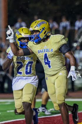 Osceola's Taevion Swint (4) and Elijah Hixson (20) celebrate a touchdown in the Kowboys' 56-6 win over St. Cloud. PHOTO/TAYLOR MCFEE