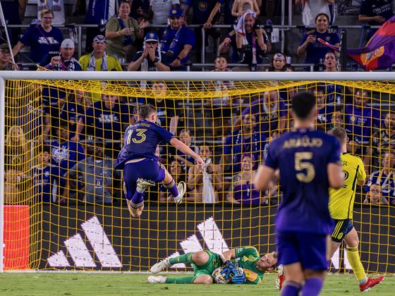 Orlando's Duncan McGuire leaps over Nashville goalie Joe Willis Saturday. The young goal scorer has signed a new multi-year deal with Orlando City SC. PHOTO/MARIO CASAMALHUAPA
