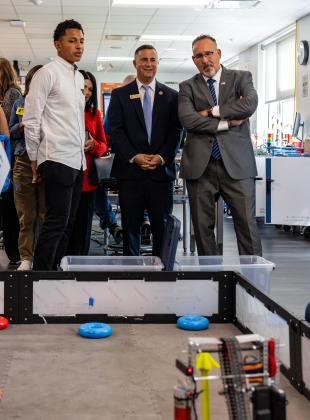Rep. Darren Soto (center) and U.S. Secretary of Education Miguel Cardona talk with a NeoCity Academy student Thursday about a robotics assignment. PHOTO/TAYLOR MCFEE