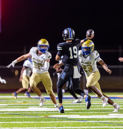 Under pressure: Armwood quarterback Rhys Brush is forced to throw under the pass rush of Osceola's Colton Carter (30) and Jeremiah Wiggins-Baker (23). PHOTO/TAYLOR MCFEE