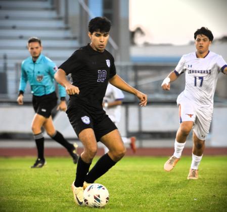 Celebration's Abraham Badillo Santana keeps possession of the ball while Harmony's Diego Bordones comes in for the challenge in Wednesday's 6-0 Storm victory in the District 7A-7 championship game. PHOTO/KATIE WILLIAMS