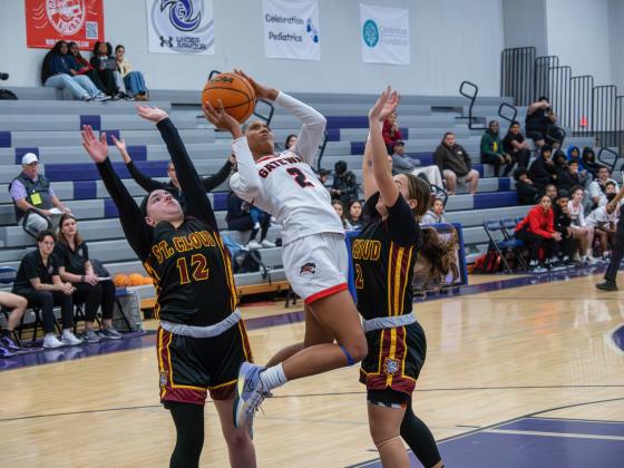 Gateway's Ashlynn Day goes up for a shot as St. Cloud's Vanessa Vohs (2) and Ava Sanchez (12) defend in Friday's OBC girls basketball championship. PHOTO/MARIO CASAMALHUAPA