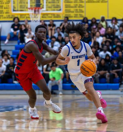 Osceola's Luke McCrimon drives past Poinciana's Kobie Brown in the Kowboys' 76-61 district championship victory Friday. PHOTO/TAYLOR MCFEE
