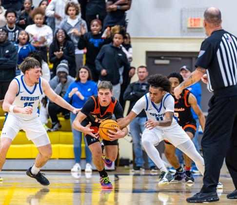 Osceola's Helio Qunian (15) and Jordan Isaac (11) defend Sarasota's leading scorer Jack Lackaff in Thursday's regional final, a 64-61 Kowboys loss. PHOTO/TAYLOR MCFEE