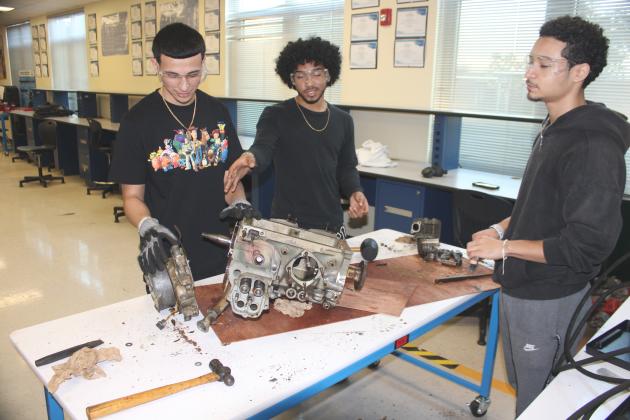 Students from the Osceola High Aviation III class teardown an aircraft engine typically used in small, propeller driven aircraft.  PHOTO/TERRY LLOYD
