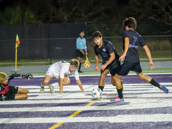 Abraham Badillo passes to Victor Mora in Celebration's 4-0 playoff win Tuesday over Fort Pierce Central. PHOTO/MARIO CASAMALHUAPA