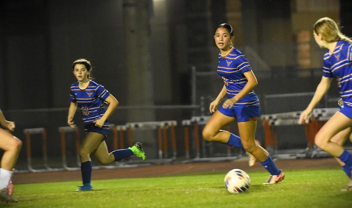 Harmony's Jadyn Frost (11), Gabriella Guzman (9) and Lily Glassburn (2) move upfield with the ball in Tuesday's 1-0 playoff win over Vero Beach. PHOTO/KATIE WILLIAMS