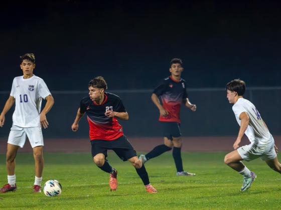 Jospeh Ramirez goes to the right trying to evade the visitors from River Ridge. PHOTO/MARIO CASAMALHUAPA
