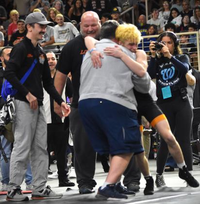 Let the emotion flow: Harmony's Nathan Lyttle gets hugs and congratulations from his Longhorns coaches like head coach Vic Lorenzano following his title-winning match Saturday. PHOTO/KATIE WILLIAMS