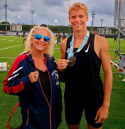 Poinciana High Class 4A state champion Levi Lee, who won the gold in the 1600 meters, with Eagles track coach Cathy Esposito Saturday at the University of North Florida. (Photo/Poinciana High)