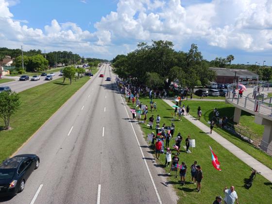 Protestors came out by the dozens to protest against the policies of President Donald Trump at Saturday's "No Kings" protest along John Young Parkway in Kissimmee. (Photo/Larry Griffin)