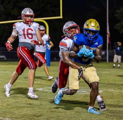 Lake Mary defenders Nazir McMillan (8) and Patrick Ryan (16) try to bring down Osceola's Jeff Sinophat in Friday's 17-12 Kowboys loss. (Photo/Dan Pearson)