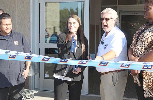 Aldi Manager Karry Johnson cuts the ribbon at Thursday’s grand opening with President and CEO of St. Cloud Chamber of Commerce Dirk Webb. (Photo/Emely Albelo)