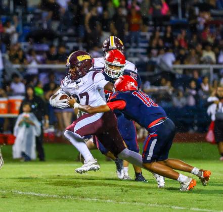 St. Cloud tailback Cameron Dalton runs through the tackle of Freedom's Camryn Williams in the Bulldogs' 55-8 win Friday. (Photo/Taylor McFee)