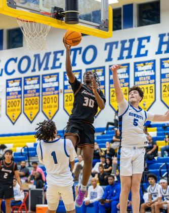 Harmony forward Kalani Stoutt goes up for two of his 14 points Tuesday as Osceola's Kaiden Zenkner (5) and Luke McCrimon (1) defend. The Kowboys won the season-opening showdown, 58-48. (Photo/Taylor McFee) 
