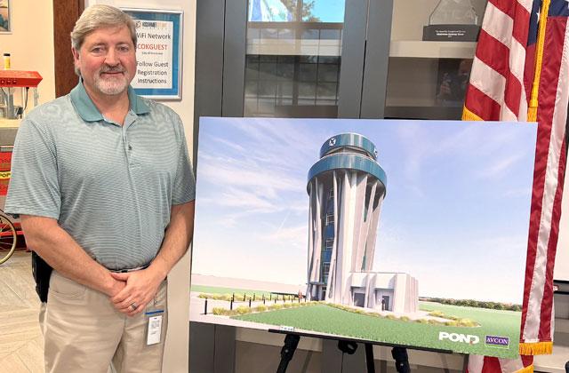Shaun Germolus, Director of Aviation for the City of Kissimmee, with an architectural rendering of the proposed new air traffic control tower, which would be located at the end of Patrick Street. (Photo/Terry Lloyd)