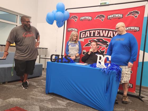Gateway High Coach Marlin Roberts (left) looks on as lineman Collin Anderson signs his scholarship Friday to Brevard (N.C.) College, as parents Carol and Christian look on. (Photo/Ken Jackson)
