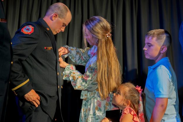 The family of new Kissimmee Fire Department Lt. Spencer Goodwin pins on his insignia at Thursday's ceremony. (Photo/City of Kissimmee)