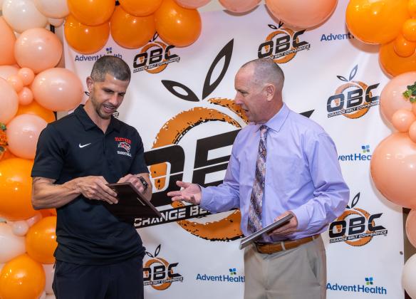 Gateway girls basketball coach Justin Marino (left) and Osceola boys coach Steve Mason, who both stepped down after this season, admire each other's Coach of the Year plaques from their schools. (Photo/Taylor McFee)