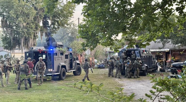 Members of the Kissimmee and St. Cloud Police Department tactical teams descend on a home on New Nolte Road Thursday morning. Eleven arrests were made and more than 60 pieces of evidence were seized. (Photo/St. Cloud Police Department)