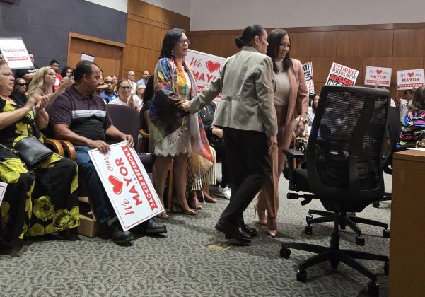 Kissimmee Mayor Jackie Espinosa (standing, center) is congratulated by her attorney Migdalia Perez Tuesday after a 2-2 vote of commissioners regarding whether to accept articles of impeachment against the mayor. The motion failed as it did not get 3 votes. (Photo/Ken Jackson)
