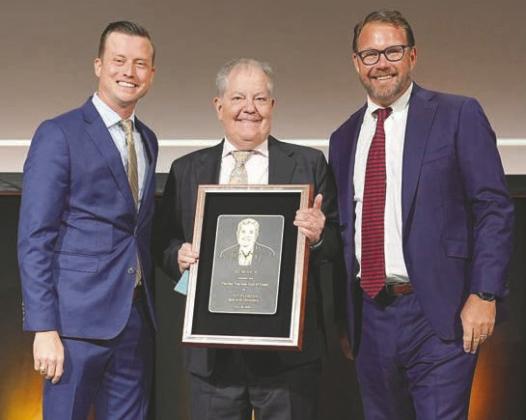 Experience Kissimmee CEO D.T. Minich (center) was recognized at last week’s Florida Governor’s Conference on Tourism in West Palm Beach. (Photo/Experience Kissimmee)