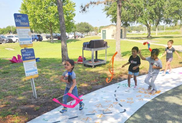 Community children ran through the ribbon to playfully open the Born Learning Trail at Peghorn Park in St. Cloud. PHOTO/KEN JACKSON