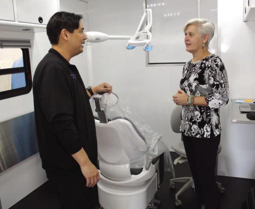 Dr. David Ferro shows County Commissioner Cheryl Grieb some of the features of the Senior Smiles Osceola mobile unit Tuesday morning parked at Hope Partnership offices. PHOTO/KEN JACKSON