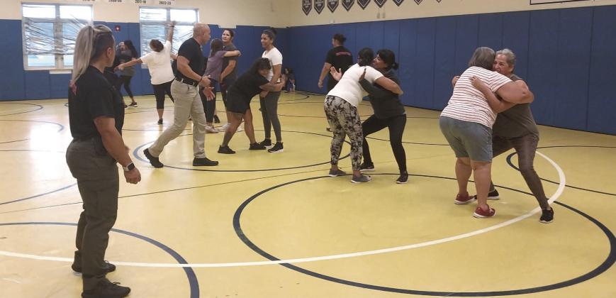 Kissimmee Police Officers Astrid Cruz and Gerardo Bellido watching as the group of women practice evasion, redirection, and escaping. PHOTO/EMELY ALBELO