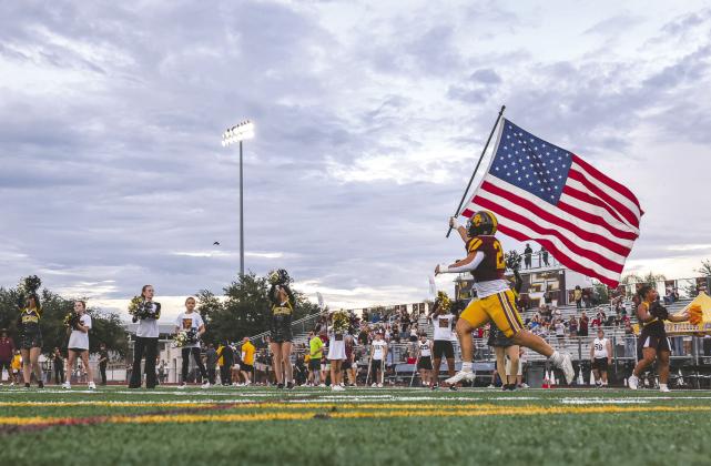 Ahead of the Bulldogs’ football game against Lake Minneola. Junior linebacker J.T. Wrona led the team on the field with the Stars and Stripes, something also done at a number of other Week 4 games Friday. (Photo/Taylor McFee)
