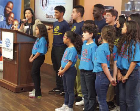 Twis Lizasuain, Board Chair for the Boys &amp; Girls Club of Osceola County, makes a presentation with club members at the “Saddle Up” fundraiser at Osceola Heritage Park on Nov. 3. PHOTO/BOYS &amp; GIRLS CLUB