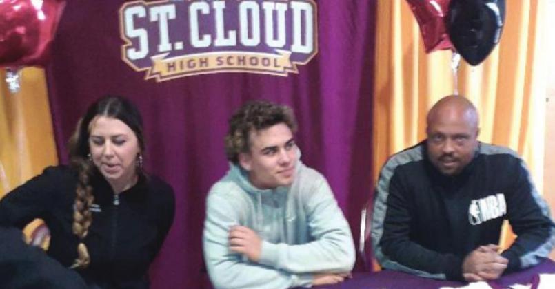 Surrounded by his parents and Shawn and Crystal, Romeo Media (center) signs his scholarship papers to attend Southeastern. NEWS-GAZETTE PHOTO/J. DANIEL PEARSON