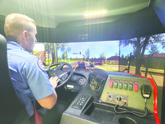 Kissimmee Firefighter Joshua Clark shows off a fire truck driving simulation in the Sim-Tech Fire Vehicle Training Simulator, which will be used to train the city’s vehicle operators. PHOTO/KEN JACKSON