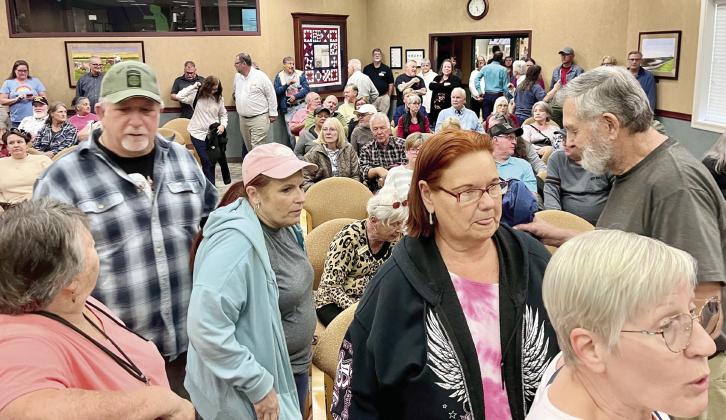 Resident Kevin Bailey expressed his concern with a sign at Monday’s meeting, while residents lined up after the meeting to voice their questions and concerns. PHOTOS/DEBBIE DANIEL