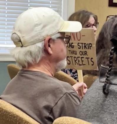Resident Kevin Bailey expressed his concern with a sign at Monday’s meeting, while residents lined up after the meeting to voice their questions and concerns. PHOTOS/DEBBIE DANIEL
