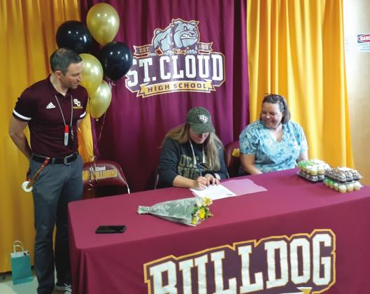 Surrounded by her mother and head coach Cory Aun, Hannah Wagner signs her letter of intent to row at the University of Central Florida. NEWS-GAZETTE PHOTO/J. DANIEL PEARSON