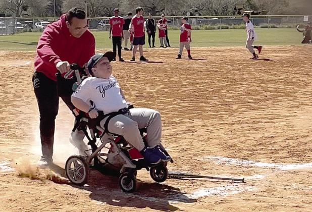 Noah Riley crosses home plate with his “buddy,” Javier Rivera, during Saturday’s Opening Day of the Challenger Division of St. Cloud Little League. PHOTO/DEBBIE DANIEL