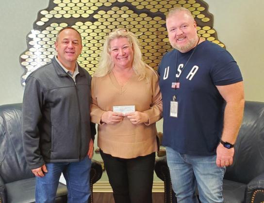 Osceola Council on Aging CEO Wendy Ford, with Warren Hogland (right), Senior Vice President for Community Action Services for the Osceola Council on Aging, accepts a donation from Blake Seaholm (left), executive director of A Place for Grace and Osceola REDI board member to help stock the St. Cloud Food Pantry, which the Council begins overseeing in 2022. PHOTO/OSCEOLA REDI