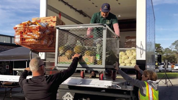 Volunteers unload the Osceola Council on Aging’s new refrigerated truck Thursday in its first day of operation at the St. Cloud Civic Center. The truck will help the Council expand its offerings, especially in warmer weather, to more outlying areas. PHOTO/CITY OF ST. CLOUD