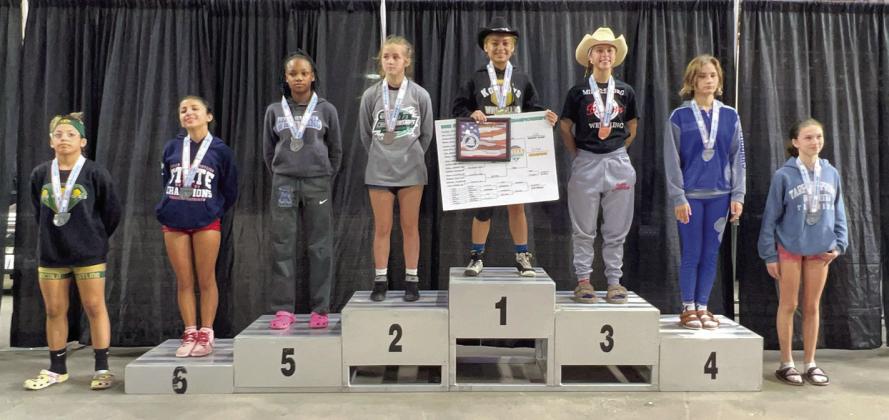 Osceola High’s Kealoni Vega (in hat on top of podium) become Osceola County’s first official FHSAA state champion when she won the 100-pound weight class in March. PHOTO/OSCEOLA HIGH SCHOOL