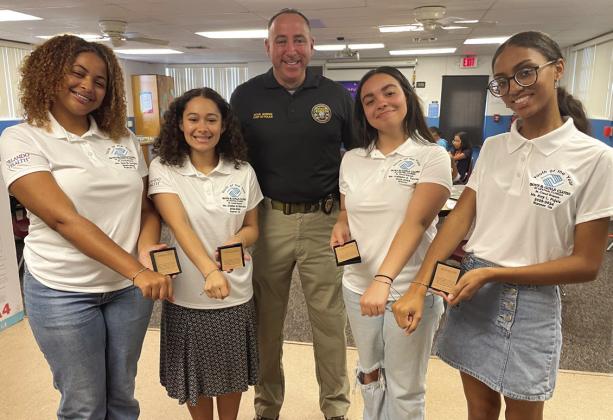 From left, Boys & Girls Club Youth of the Year Finalists (from left) Asia Douglas, Kaitlynn Torres, Aidalise Marcano and Emy Pujols show off the “Going Places” bracelets awarded by St. Cloud Police Chief Doug Goerke (center). SUBMITTED PHOTO