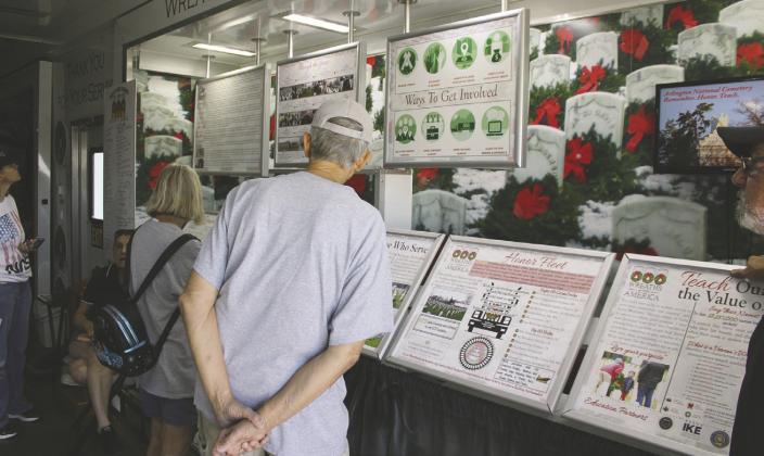 Visitors review educational displays inside the Wreaths Across America Mobile Education Exhibit at St. Cloud’s Centennial Park April 14. PHOTO/TERRY LLOYD