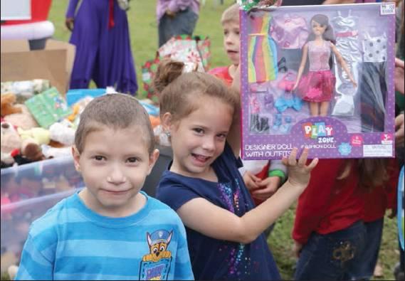 NEWS-GAZETTE PHOTOS/NANCY BRIGHAM Above, Diane Potocnak, 6, shows off her new Barbie, with her 6-year-old brother, James. Below, bikes are ready for distribution.
