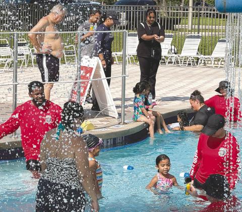 Members of the Osceola Sheriff’s team got in the water with participants at a water safety camp last week at the Kissimmee YMCA. (Photo/David Chivers)